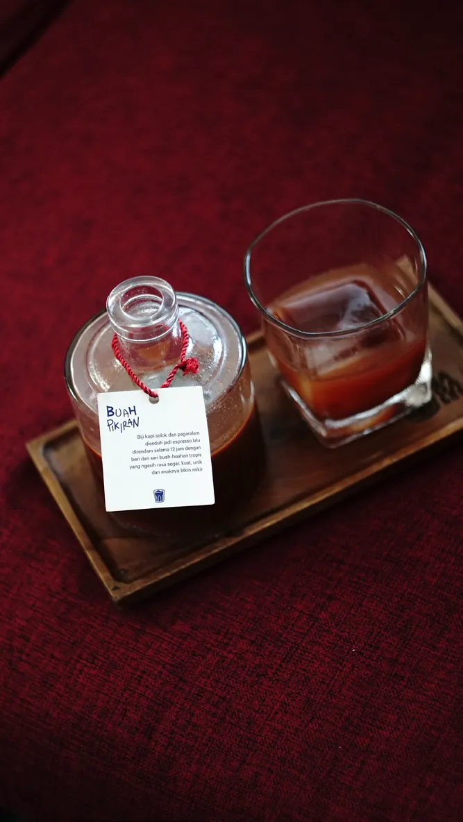 Botol kaca berisi Buah pikiran dengan tali merah dan label
